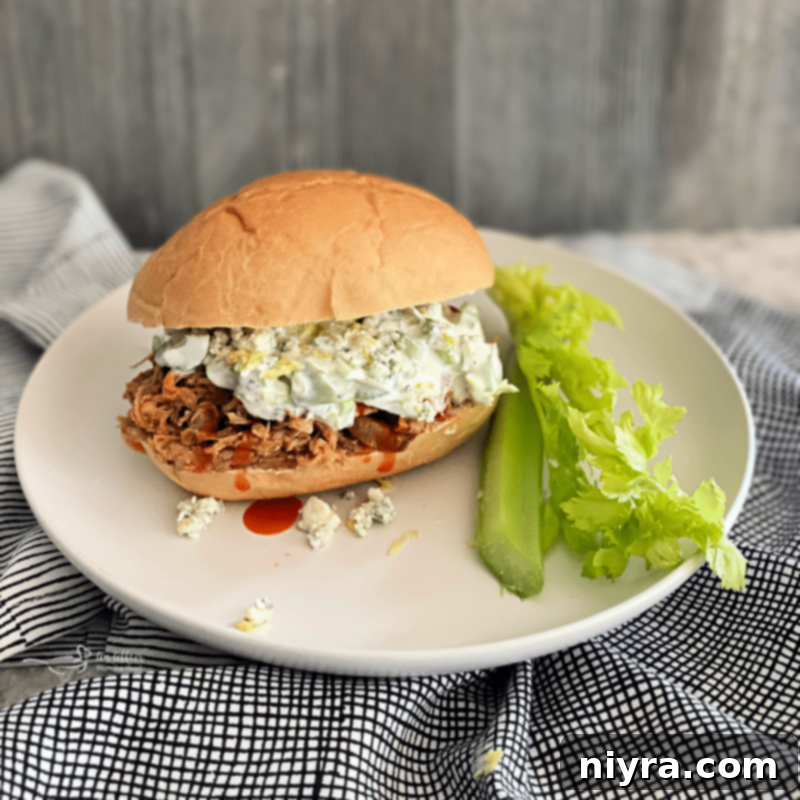 Slow cooker buffalo pulled pork sandwich with celery slaw on a white plate
