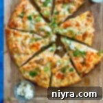 A sliced buffalo chicken pizza on a wooden platter