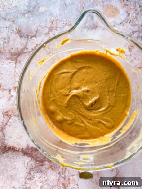 Cinderella Pumpkin Bundt Cake with Cream Cheese Frosting 9 Mixing pumpkin and vanilla into the cake batter