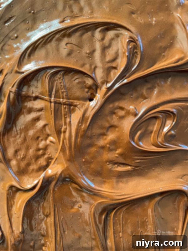 Smooth, melted chocolate coating the toffee graham crackers, ready for the final touches.