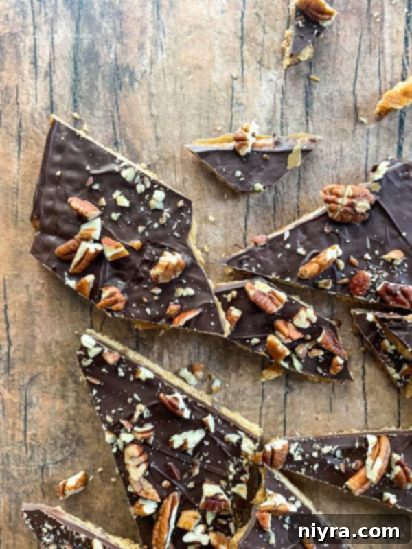 Broken pieces of golden toffee graham cracker brittle on a serving dish, highlighting the crunchy texture.