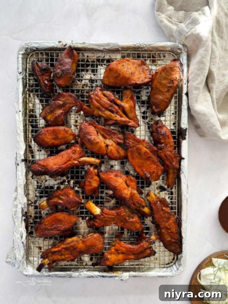 Brushing Dr. Pepper BBQ sauce onto the cooked ribs.