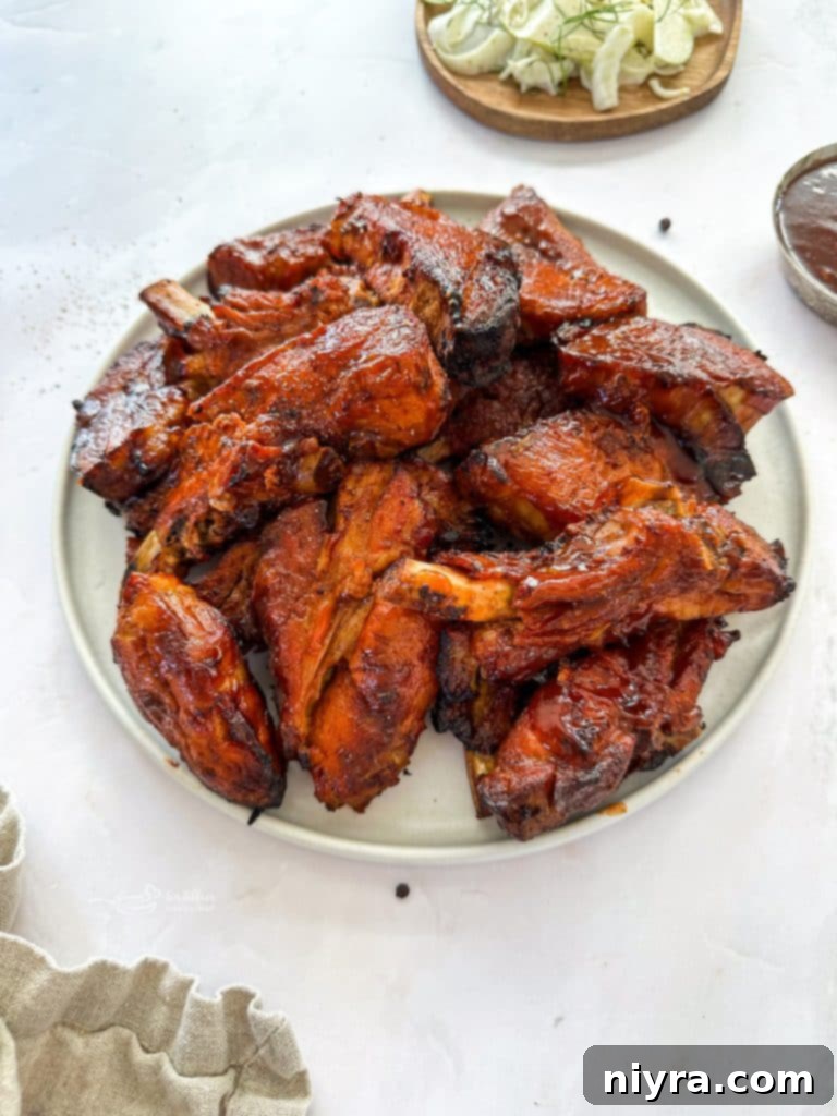 Slow Cooker Dr. Pepper Ribs on a white platter, garnished with fresh parsley.