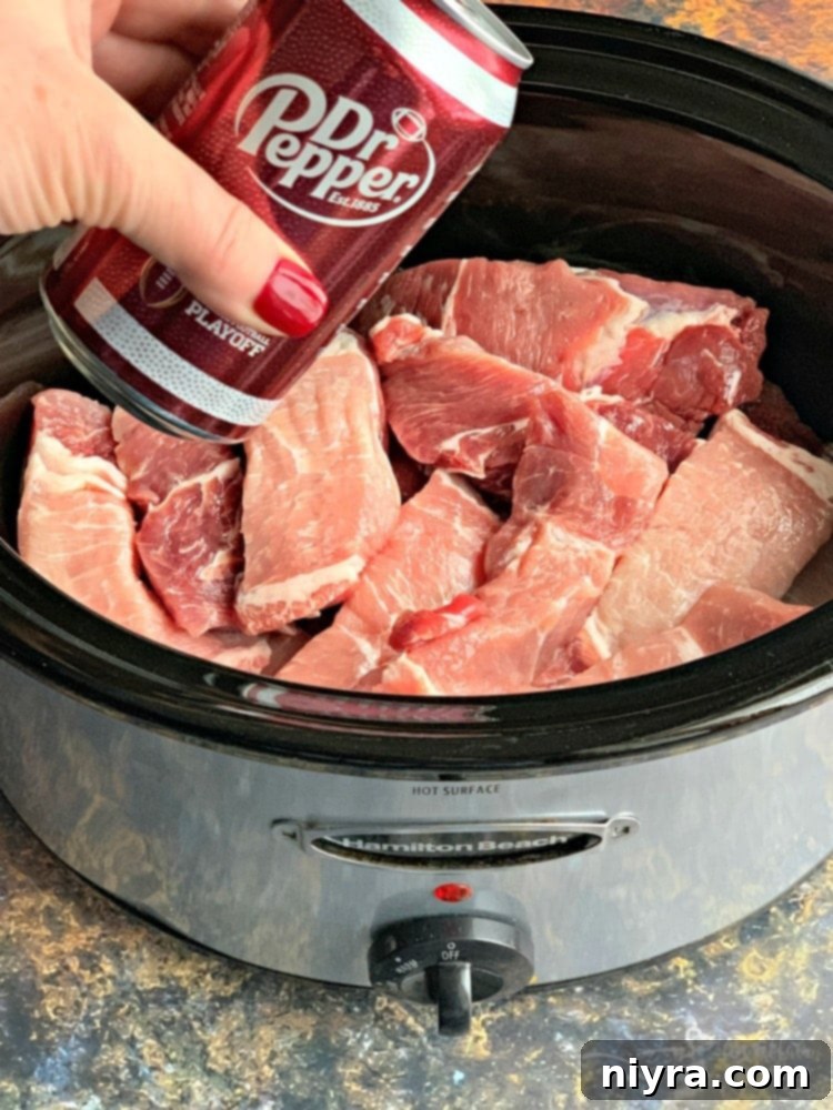 Slow Cooker Dr. Pepper BBQ Ribs prep - Dr. Pepper being poured over raw ribs.