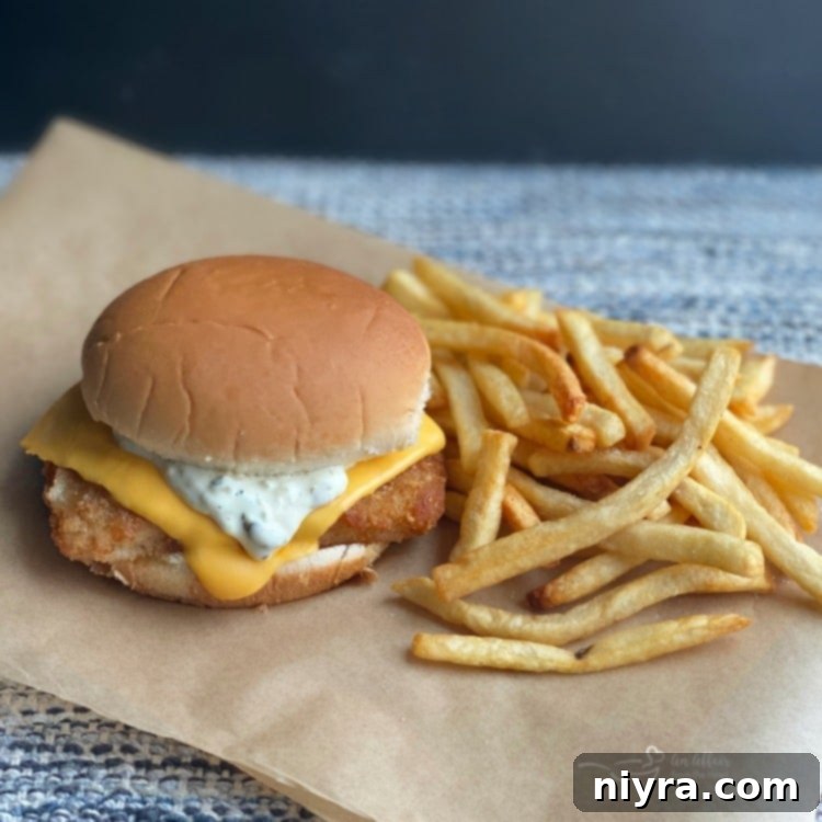 A homemade Filet-O-Fish sandwich served with french fries, ready to eat.