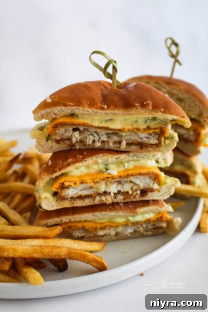 Two homemade Filet-O-Fish sandwiches on a wooden board, highlighting the soft buns and visible tartar sauce.