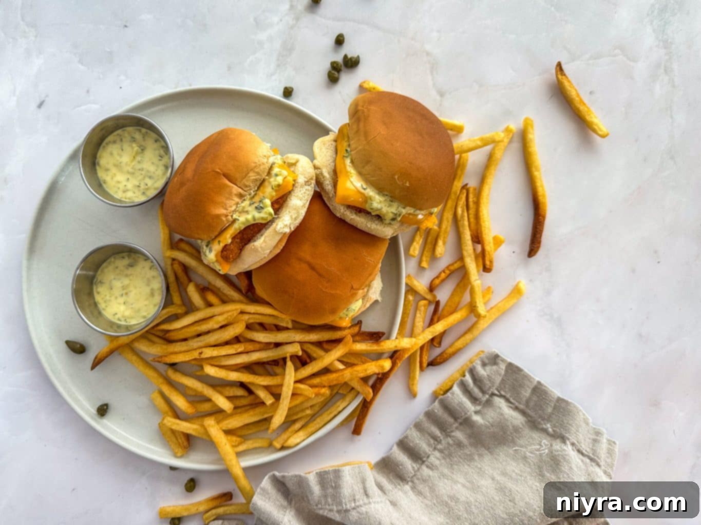 Ingredients for homemade Filet-O-Fish, including breaded fish, buns, cheese, and tartar sauce components.