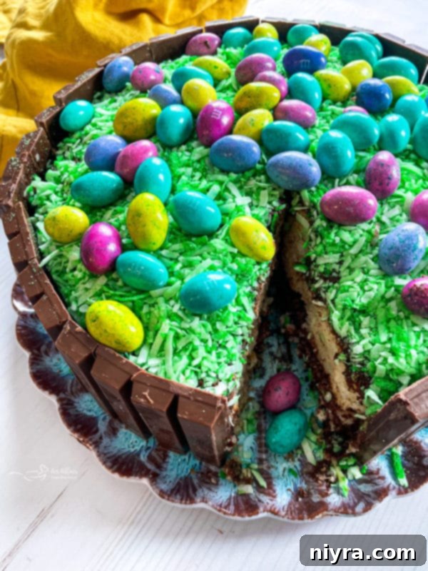 A perfectly sliced Kit Kat Easter Basket Cake revealing its soft yellow interior and rich chocolate frosting, surrounded by Kit Kat bars.