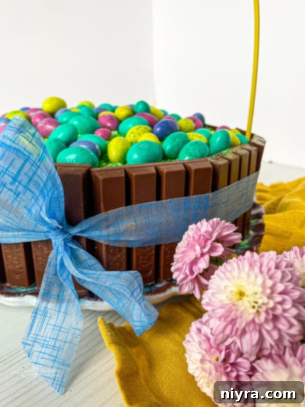 A beautifully arranged Easter display featuring the Kit Kat Easter Basket Cake as its centerpiece, surrounded by festive decorations.