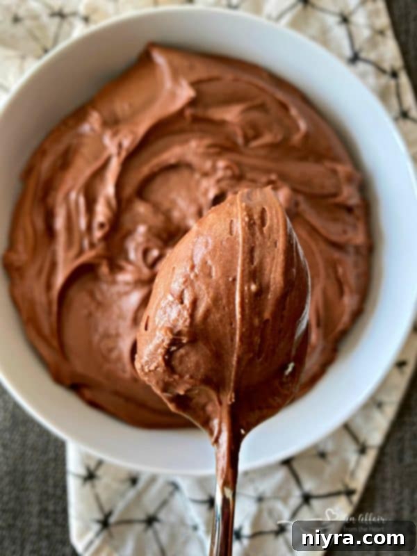 Sour cream chocolate frosting glistening on a spoon