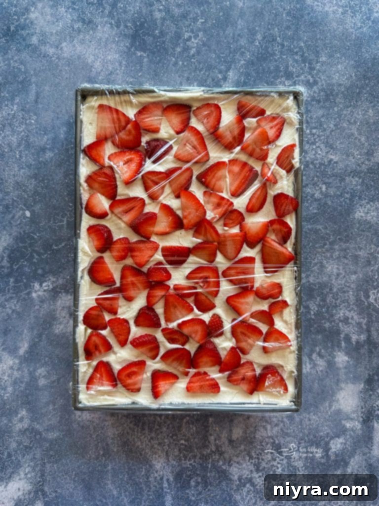 The finished Strawberry Icebox Cake covered with plastic wrap, ready for chilling.