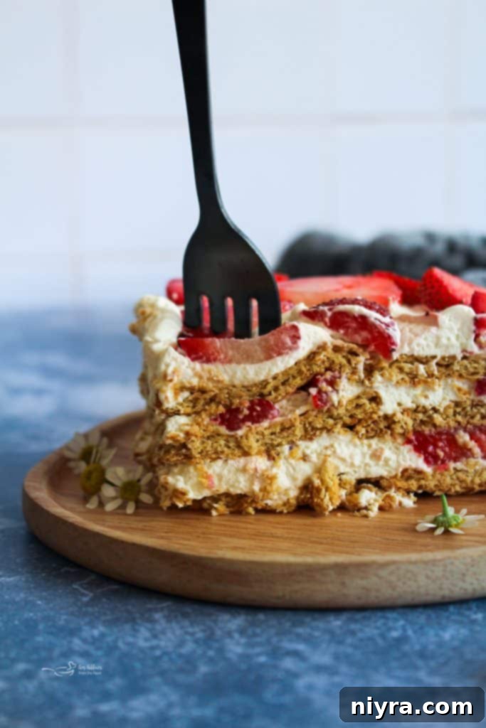 Close-up of a slice of Strawberry Icebox Cake showing creamy layers.