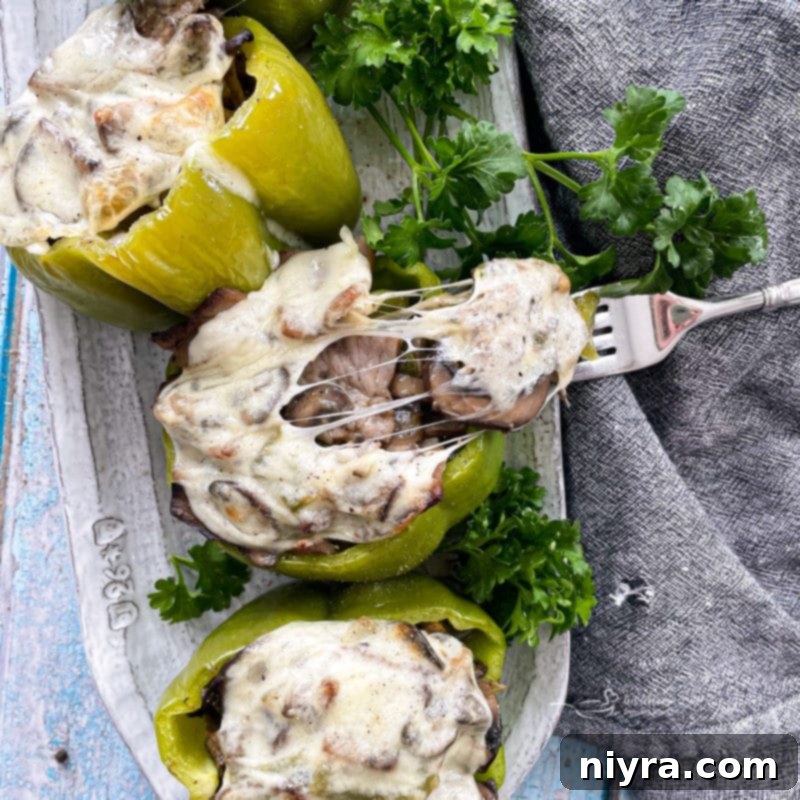 Loaded Philly Cheesesteak Peppers 16 Philly Cheesesteak Stuffed Peppers with a bite taken, showcasing the filling