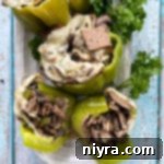 Loaded Philly Cheesesteak Peppers 22 Stuffed peppers with Philly cheesesteak filling and garnishes, ready to serve