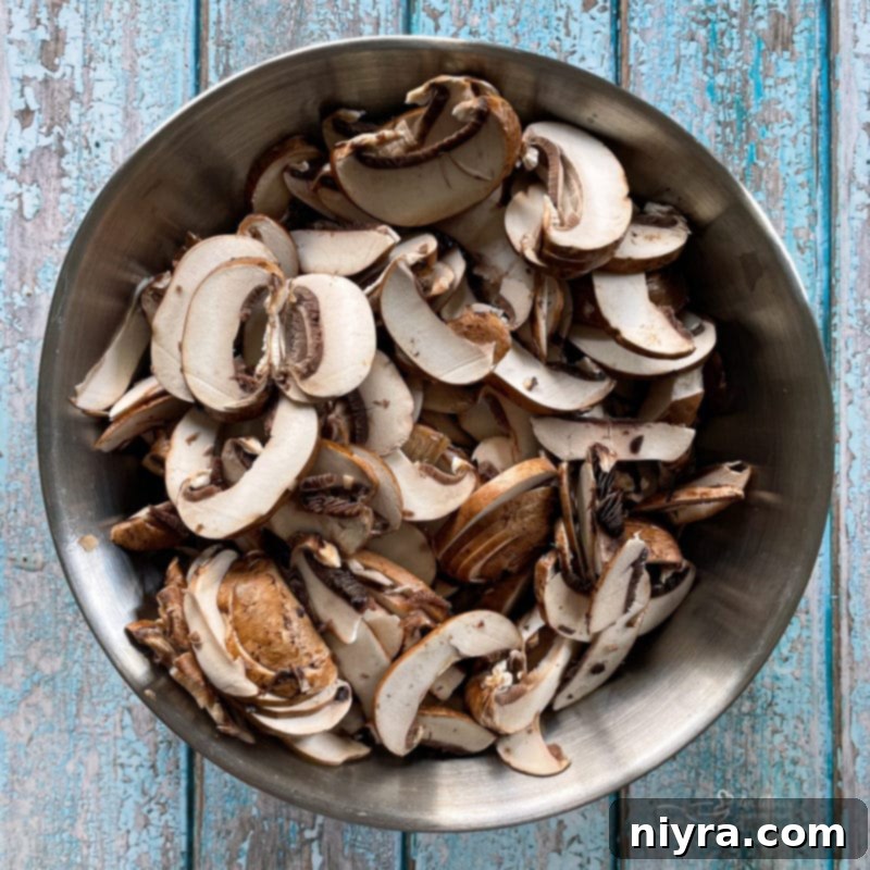 Loaded Philly Cheesesteak Peppers 7 Sliced mushrooms in a bowl, ready for cooking