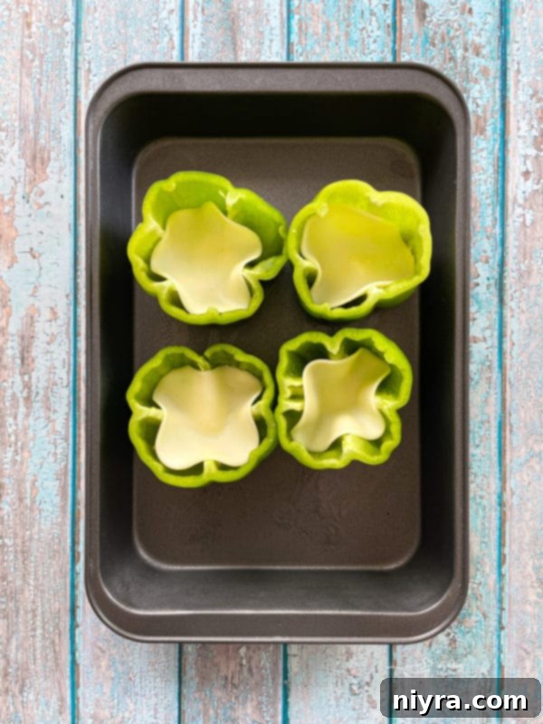 Loaded Philly Cheesesteak Peppers 9 Bell peppers with provolone cheese slices at the bottom in a baking dish
