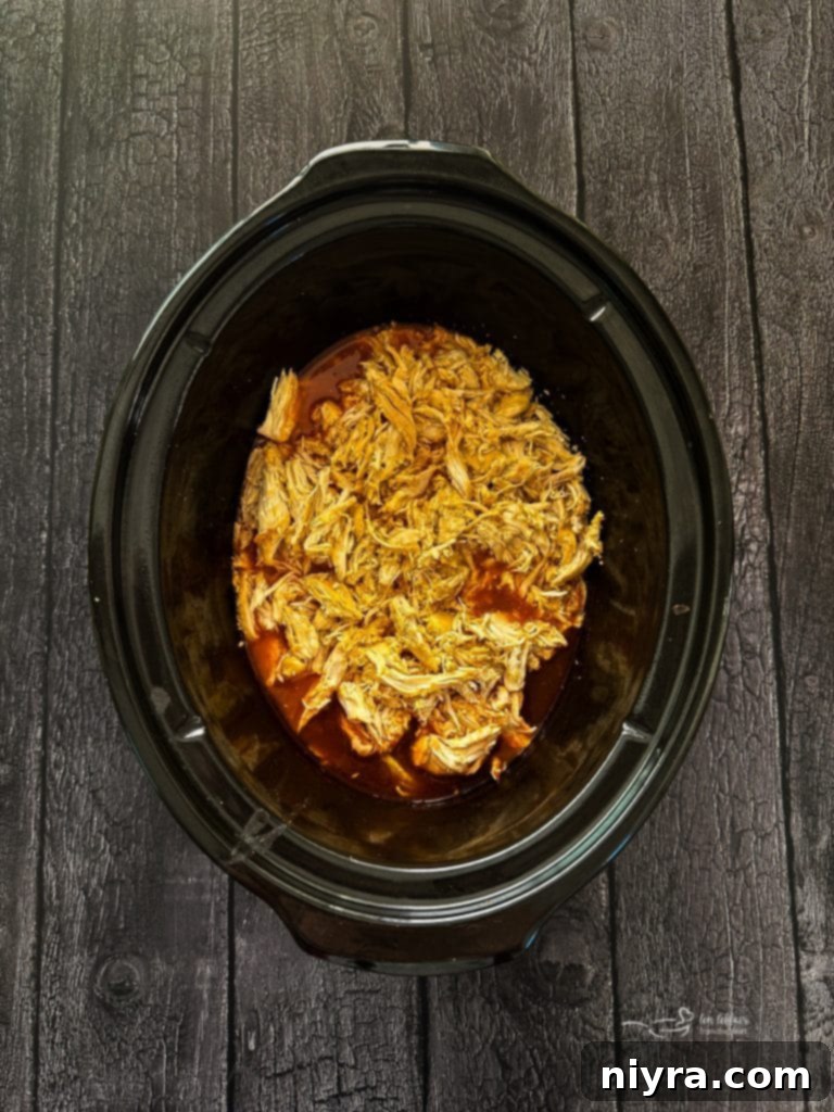 Crisp Buffalo Chicken Lettuce Wraps 9 Shredded buffalo chicken being stirred back into the sauce in the slow cooker