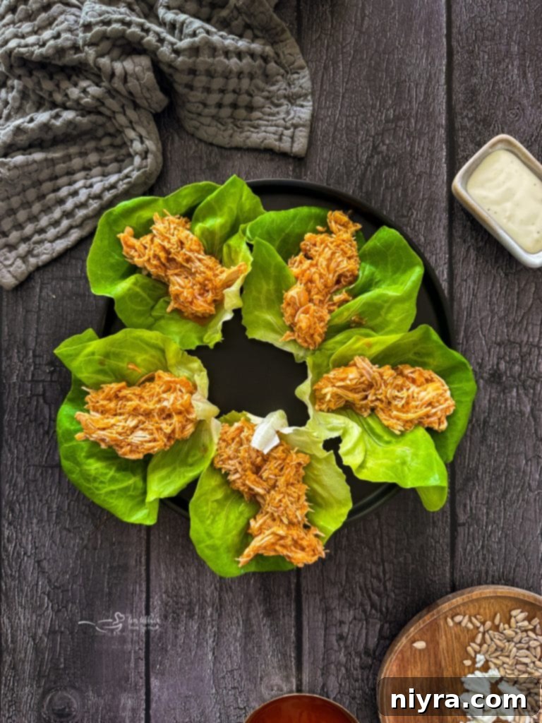 Crisp Buffalo Chicken Lettuce Wraps 10 Filling a lettuce leaf with shredded buffalo chicken