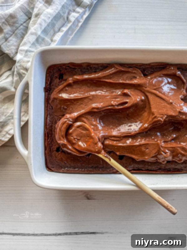 Poking holes in the cake with a wooden spoon handle