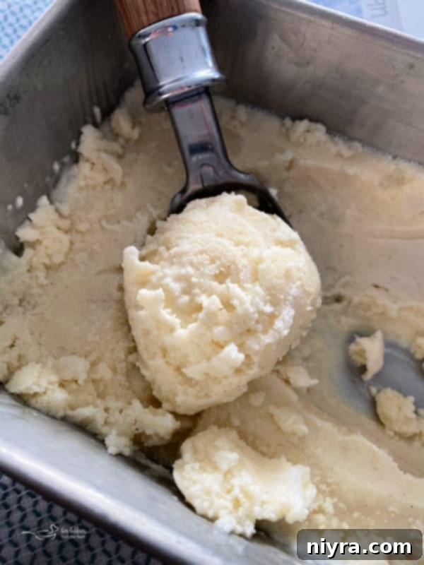 Snow ice cream mixture poured into a metal loaf pan for freezing