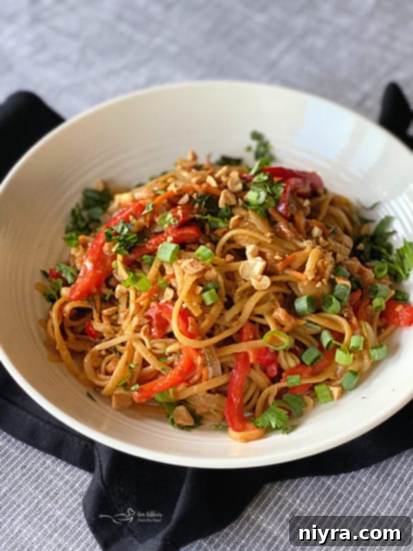 One-Pot Italian Magic 3 Pad Thai Wonderpot in a white bowl, showcasing colorful noodles and fresh vegetables