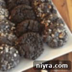 Dark Chocolate Molasses Cookies layered on a white serving tray