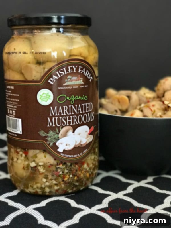 Jar of Paisley Farms Organic Marinated Mushrooms, highlighting the quality ingredients for gourmet appetizers.