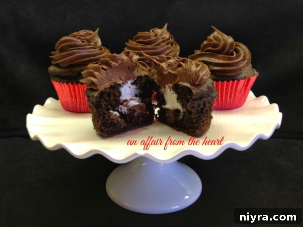 Three perfectly frosted chocolate cupcakes with cream filling visible