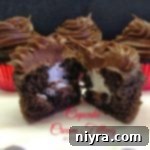 A chocolate cupcake cut in half, revealing the luscious cream filling inside, with accompanying text "Cupcake Cream Filling"