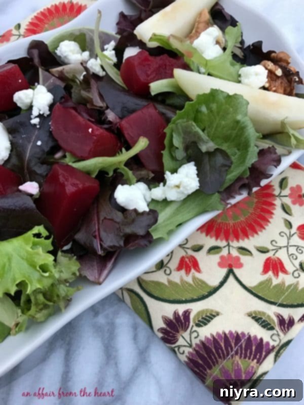 Ingredients for the pickled beet salad thoughtfully arranged: fresh spring mix, colorful pickled beets, sliced pears, walnuts, and crumbled goat cheese