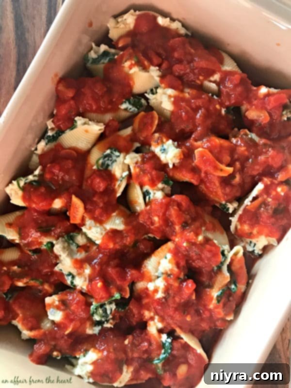 Spinach & Artichoke Stuffed Shells arranged in a pan, ready for sauce and baking