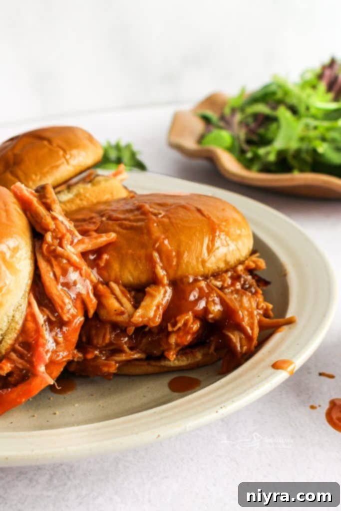 Shredded Dr. Pepper BBQ pork in a slow cooker, simmering in its sauce.