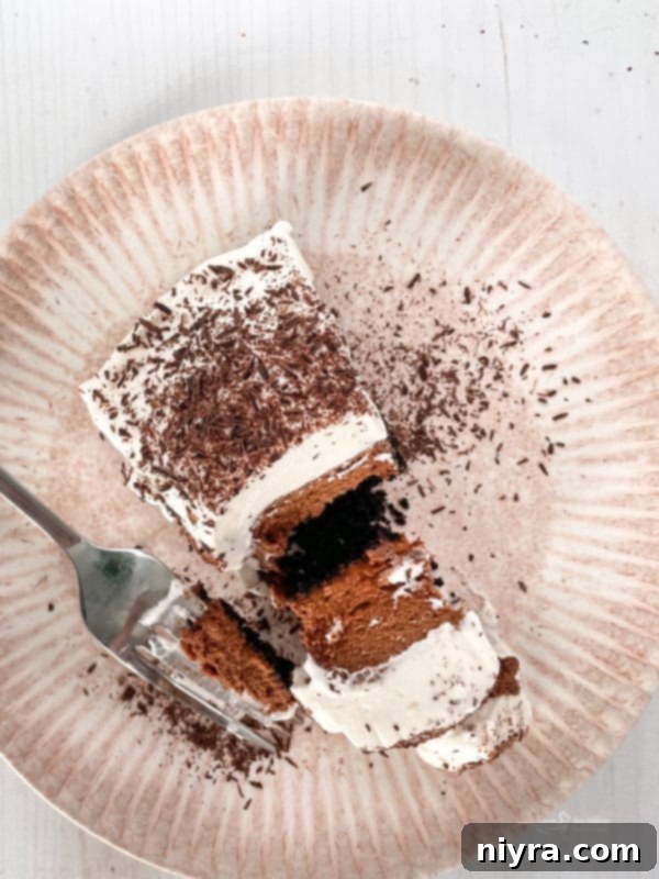 A perfectly sliced French Silk Pie on a white plate, showcasing its creamy chocolate filling and whipped topping.