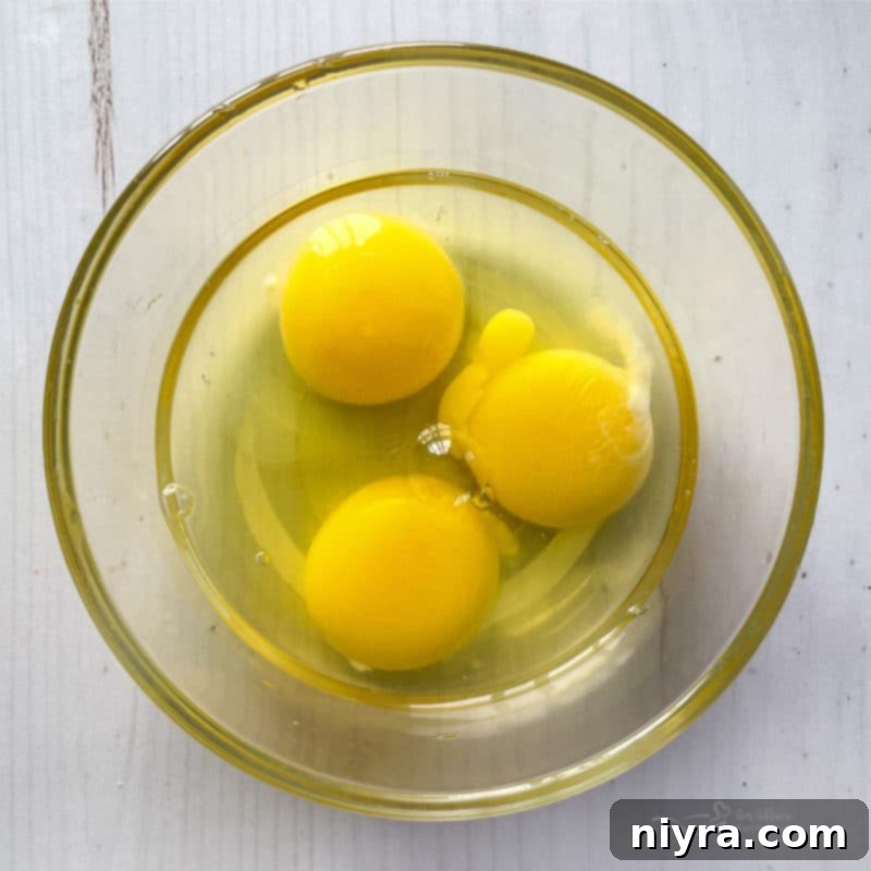 Top view of three fresh eggs in a bowl, ingredients for baking.