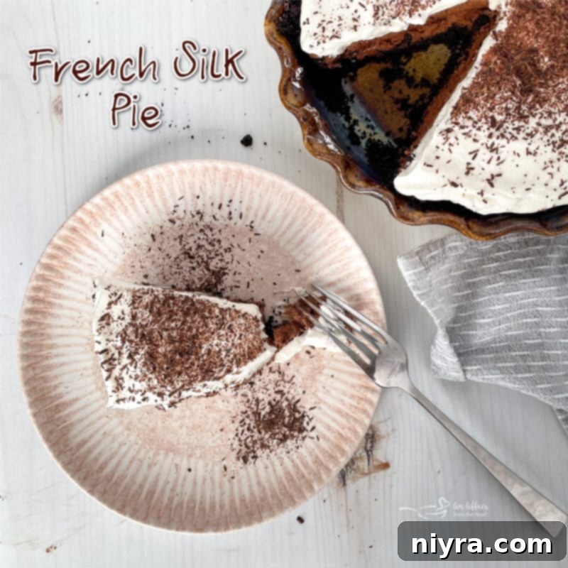 Top view of a slice of French Silk Pie on a white plate with a fork, garnished with chocolate curls.