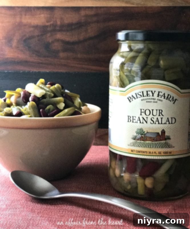 Paisley Farm Four Bean Salad in a serving bowl with a spoon