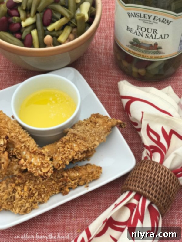 A serving of spicy baked chicken tenders with a side of Paisley Farm Four Bean Salad