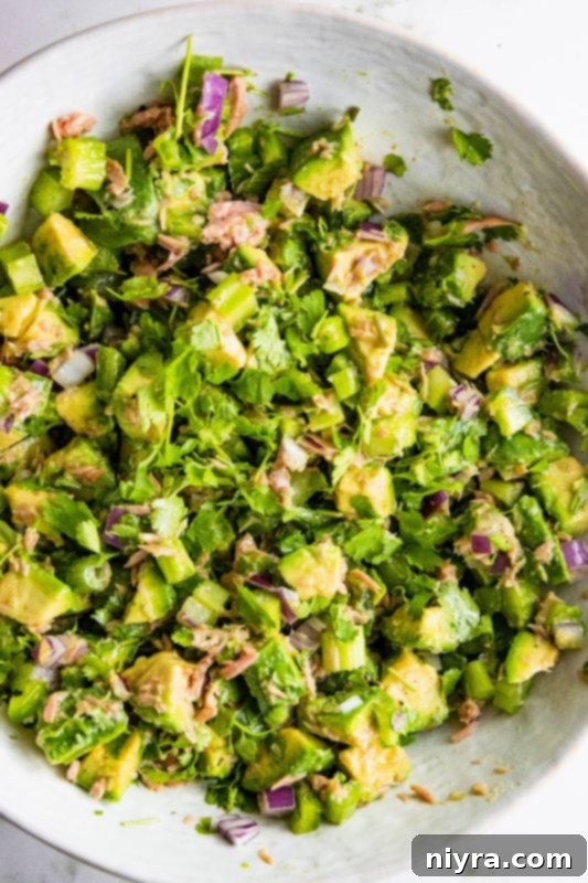 Close-up of Avocado Tuna Salad with a fork, highlighting the fresh diced ingredients.