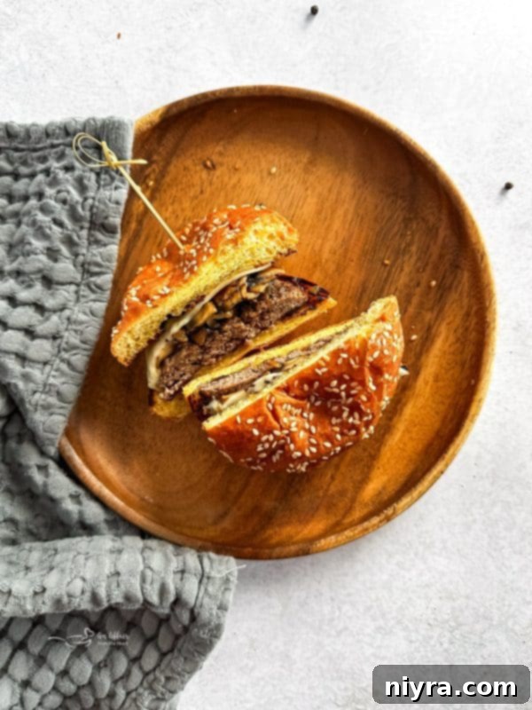 A close-up shot of a Mushroom Swiss Burger, perfectly stacked.