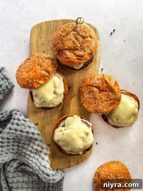 A delicious Mushroom Swiss Burger with a side of fries and a drink.