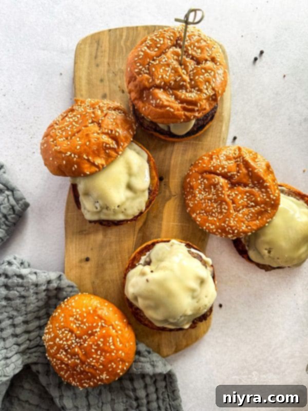 Ingredients for Mushroom Swiss Burger laid out on a cutting board, including mushrooms, cheese, and a beef patty.