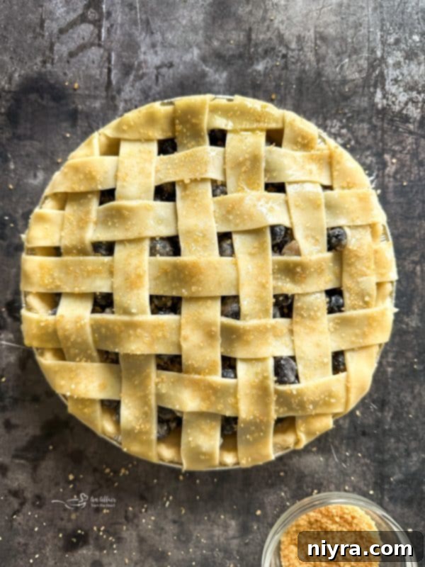 Lattice top crust being placed on the blueberry pie
