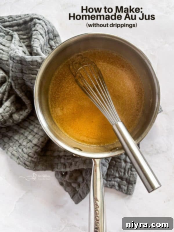 Homemade Au Jus, served in a gravy boat, next to roasted meat.