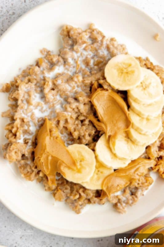 A bowl of Instant Pot Cinnamon Oatmeal topped with fresh berries and a drizzle of maple syrup, placed on a wooden table.