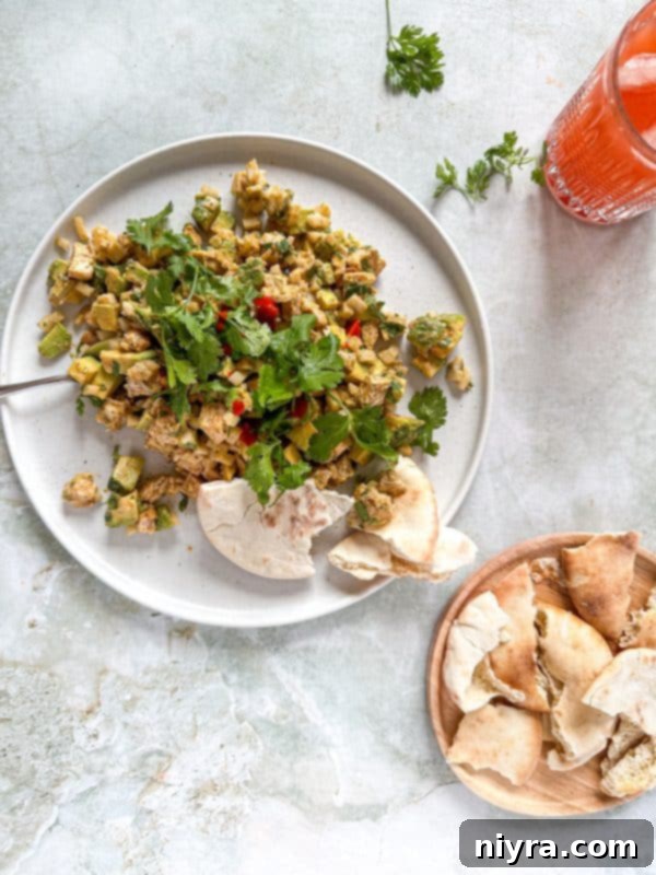 A bowl of Avocado Chicken Salad Dip with a spoon scooping some out, showing the creamy texture.