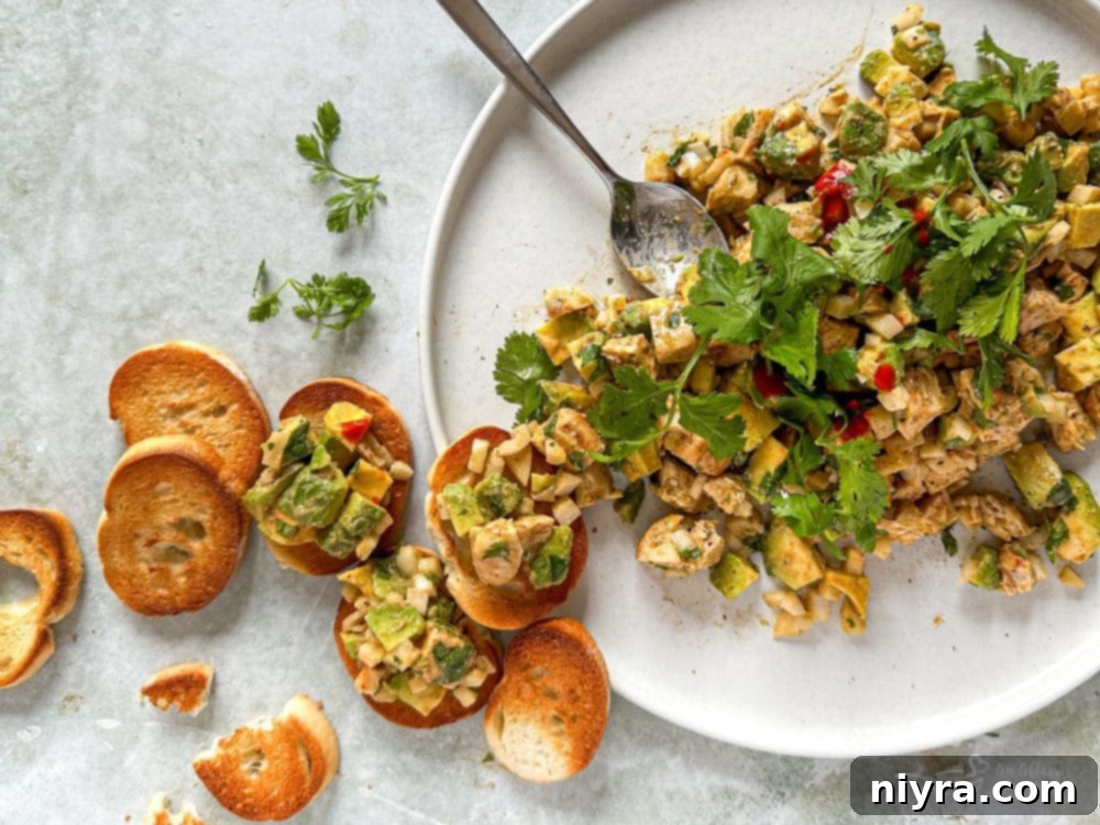 Avocado Chicken Salad Dip in a bowl with pita bread slices, ready to be served.