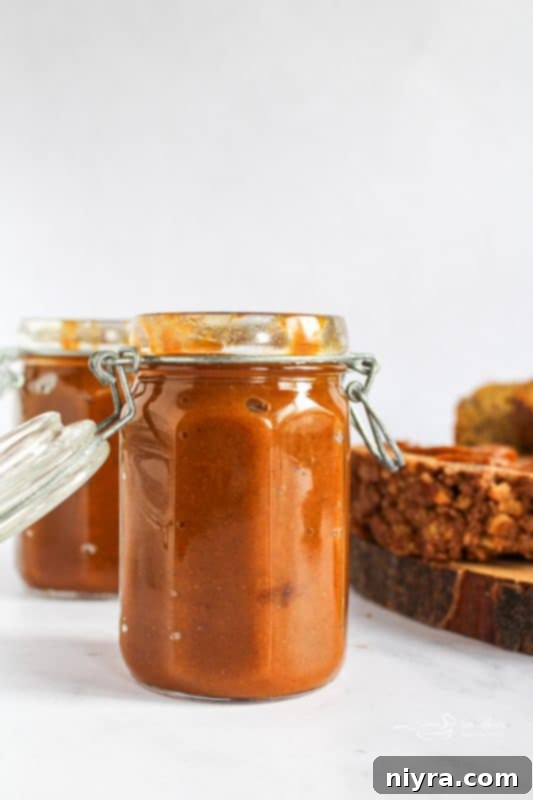 Freshly made pumpkin butter in a glass jar, ready to be enjoyed.