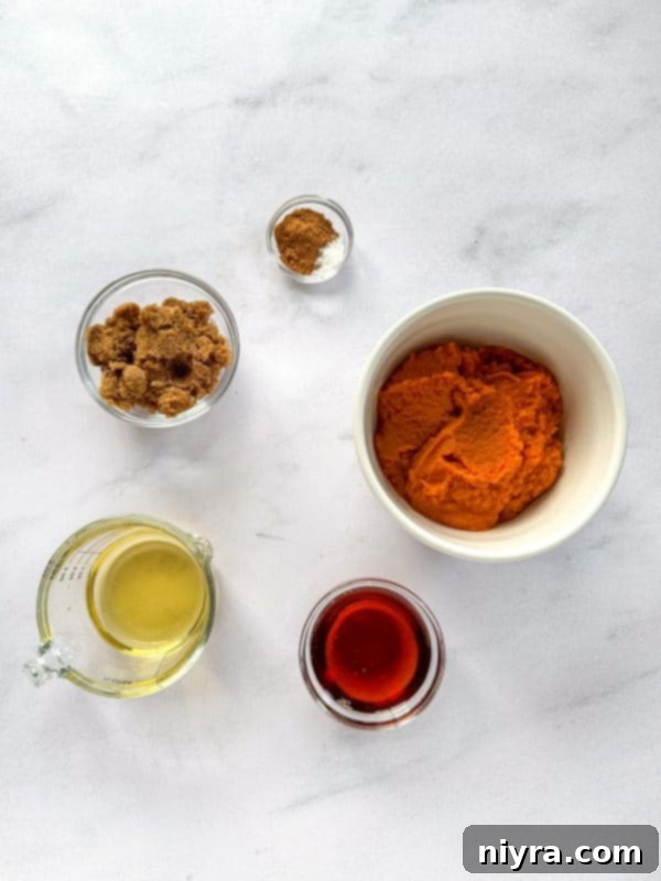 An open jar of pumpkin butter with a serving spoon inside, highlighting its creamy texture.