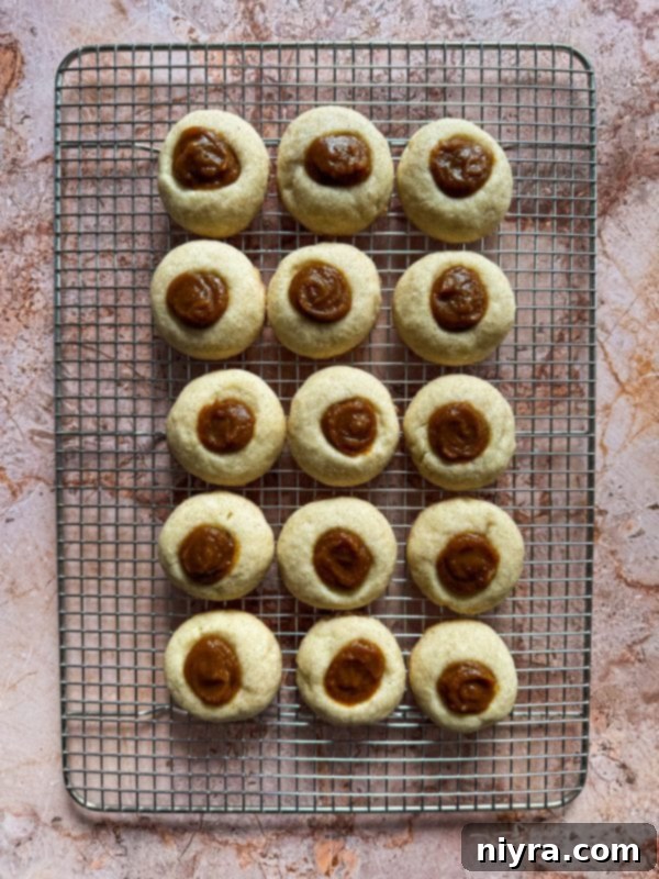 Filling baked Snickerdoodle Thumbprint Cookies with creamy pumpkin butter before serving.