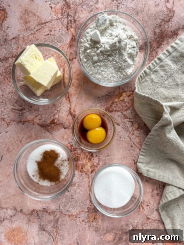 A top-down view of several Snickerdoodle Thumbprint Cookies, beautifully arranged, highlighting their golden-brown edges and vibrant pumpkin butter centers.
